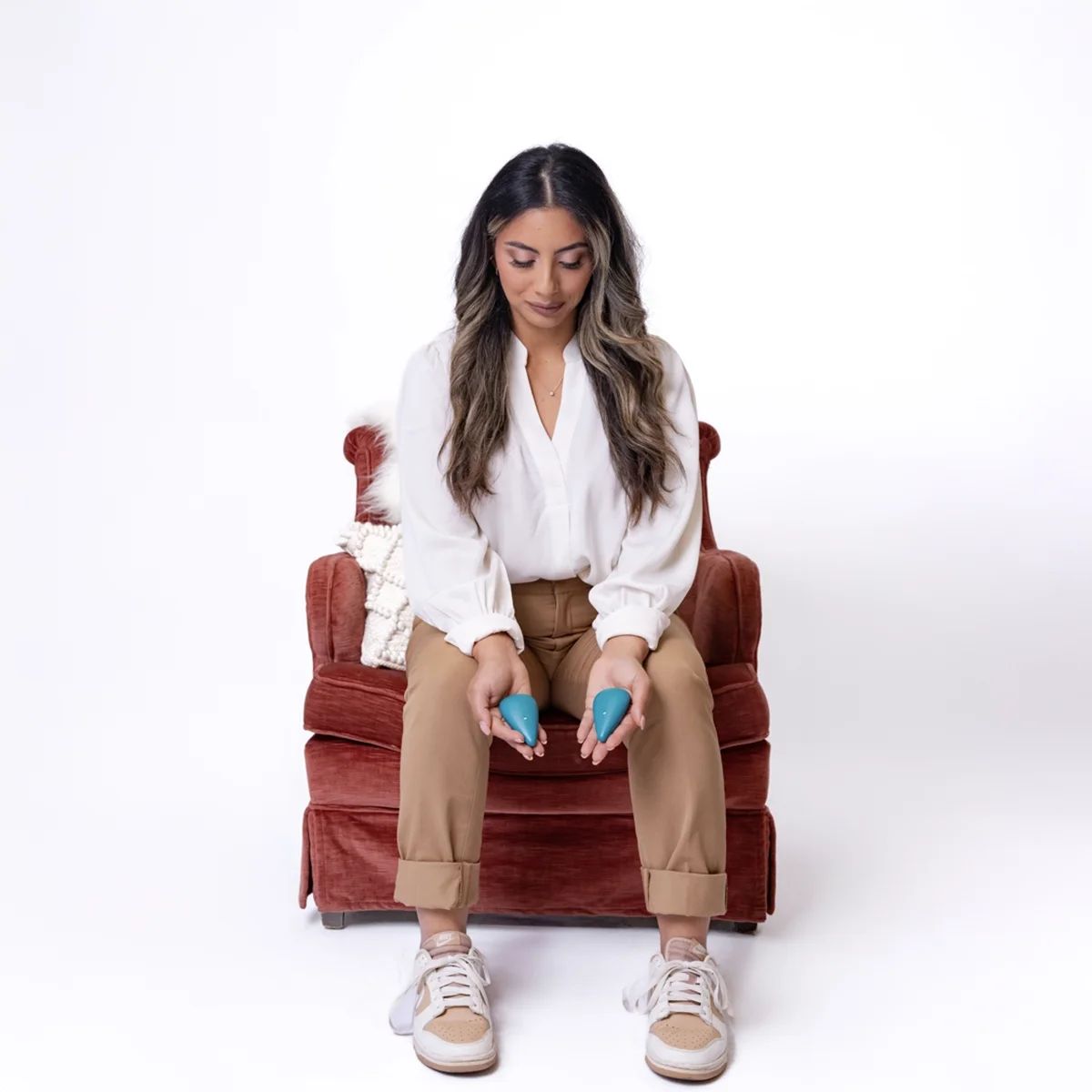 Woman sitting in a chair holding two blue objects